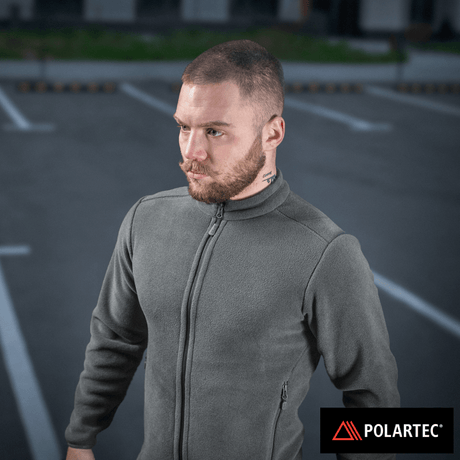 M-Tac Nord Polartec -fleecetakki harmaana, valmistettu Polartec® 200 Series -fleecestä, pidetty miehen yllä parkkipaikalla.