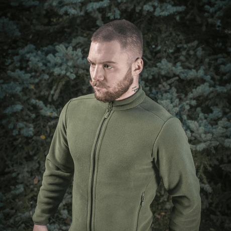 Mies pukeutuneena M-Tac Nord Polartec -fleecetakkiin luonnossa, premium-lämmin fleecemateriaali, tyylikäs ja toimiva arkeen ja urheiluun.