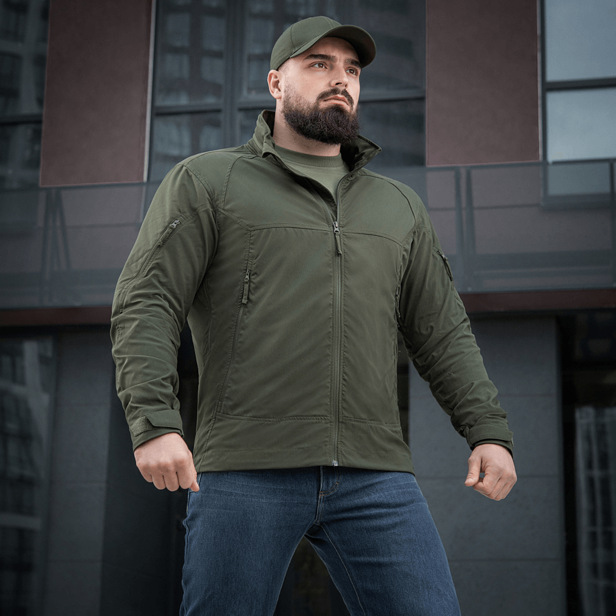 Mies pukeutuneena vihreään M-Tac Flash -takkiin vaellukseen ja urheiluun, kevyt, monikäyttöinen ja helppo yhdistää muuhun vaatetukseen.