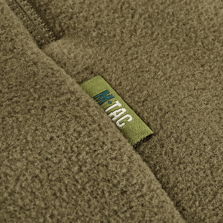 Lähikuva M-Tac Sprint Fleece Sweatshirt Polartec -etiketistä oliivinvihreällä fleece-kankaalla.