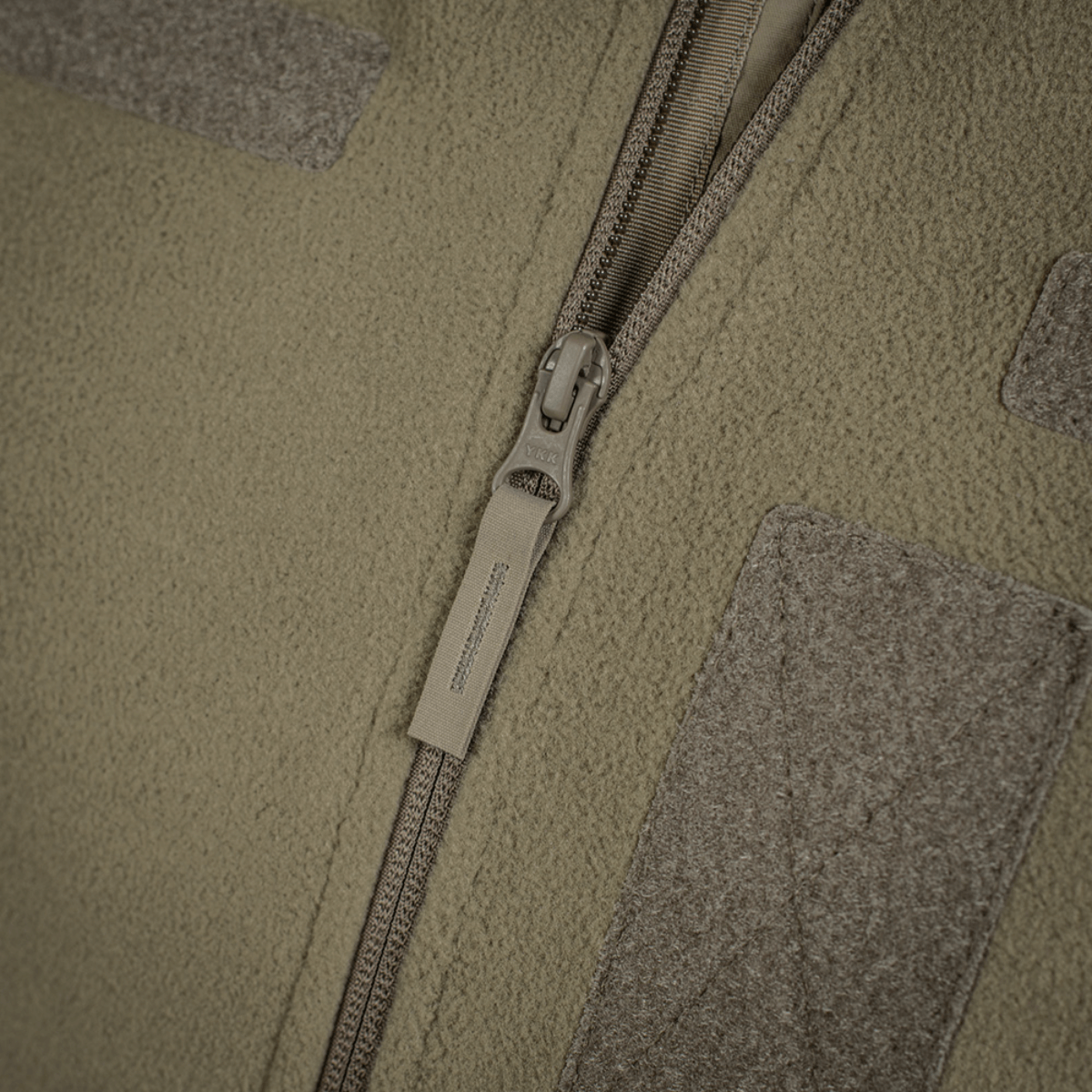 Yksityiskohta M-Tac Combat Fleece Polartec -takista, YKK-vetoketju ja Velcro-paneelit, korkealaatuinen.
