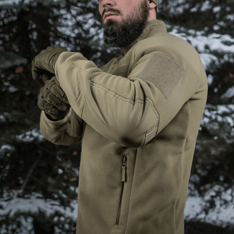 Henkilö M-Tac Combat Fleece Polartec -takissa luonnossa, sopii taktiseen ja arkikäyttöön kylmässä säässä.