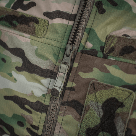 Lähikuva M-Tac Alpha Gen.IV Pro Primaloft -takista Multicam-kuosilla ja Brookwoodin vettähylkivällä kalvolla.