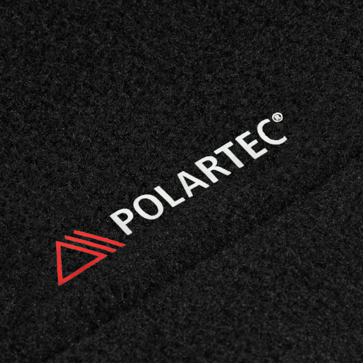 Lähikuva mustasta Polartec® 200 Series -fleece-kankaasta, jota käytetty M-Tac Sweater Nord Fleece Polartec -naismallissa, Polartec-logo näkyvissä.