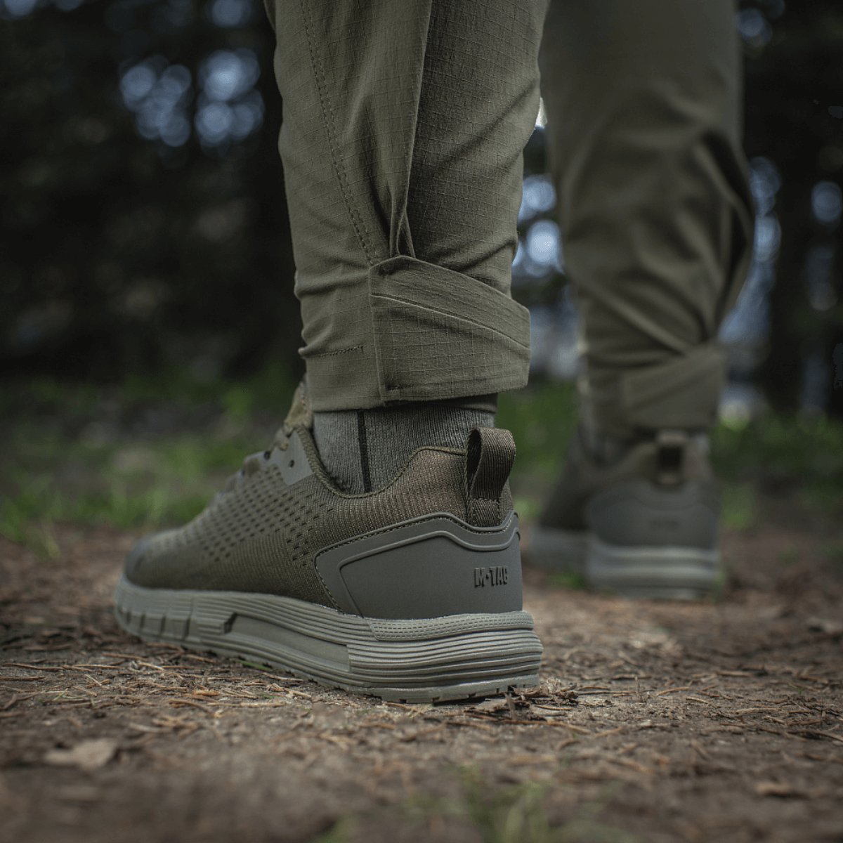 M-Tac Aggressor Summer Flex -housut metsäympäristössä, näyttää lahkeen ja kengän yksityiskohtia