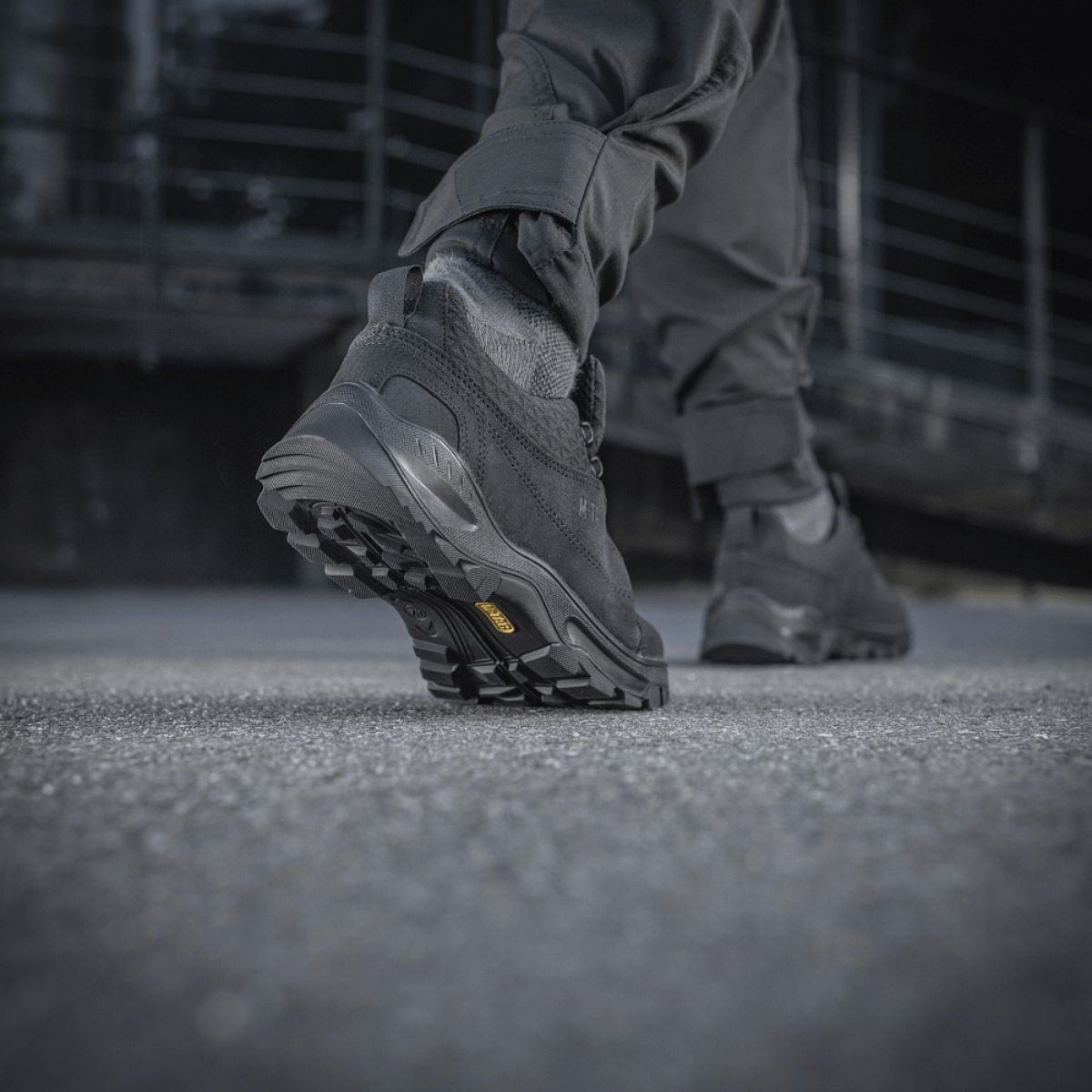 Mies kävelee betonipinnalla M-Tac Tactical Sneakers Patrol R Vent -kengät jalassaan, näkyy kestävä kumipohja.