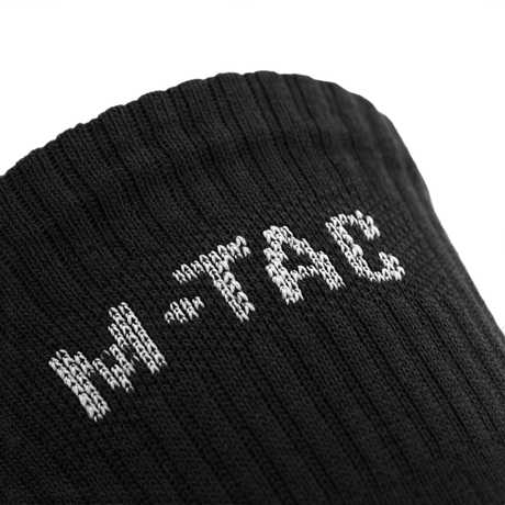 Lähikuva M-Tac Høje Sokker Mk.2 -sukista logolla, suunniteltu tukea ja mukavuutta varten trekkingissä.