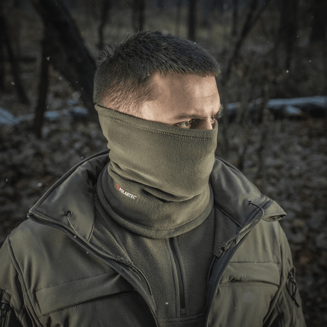 M-Tac Tube Scarf Polartec metsäympäristössä, sopii kylmiin vuodenaikoihin ja ulkoiluun, käytettävissä kaulurina tai kasvomaskina.