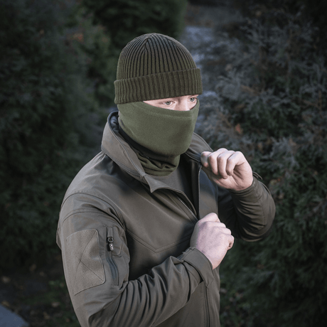 Mies käyttää M-Tac Tube Scarf Polartec kasvomaskina, seisoo ulkona valmiina kylmän kauden aktiviteetteihin.