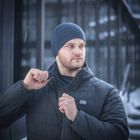 Mies pukeutuneena M-Tac Fleece Watch Cap Light Polartec ja takki talvisäässä.