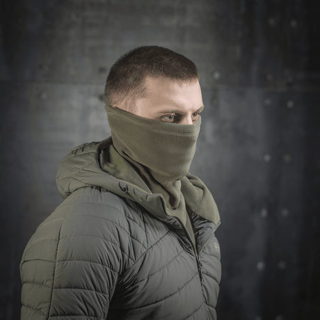 M-Tac Polartec Anatomic Tube Scarf käytettynä kasvomaskina metallitaustaisessa ympäristössä, näyttää monipuolisuutta ja tyyliä.