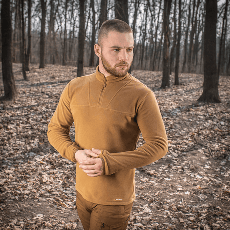 Mies pukeutuneena M-Tac Delta Polartec fleece-takkiin metsässä, lämmin ja hengittävä takki, sopii kylmiin päiviin puolivetoketjulla.