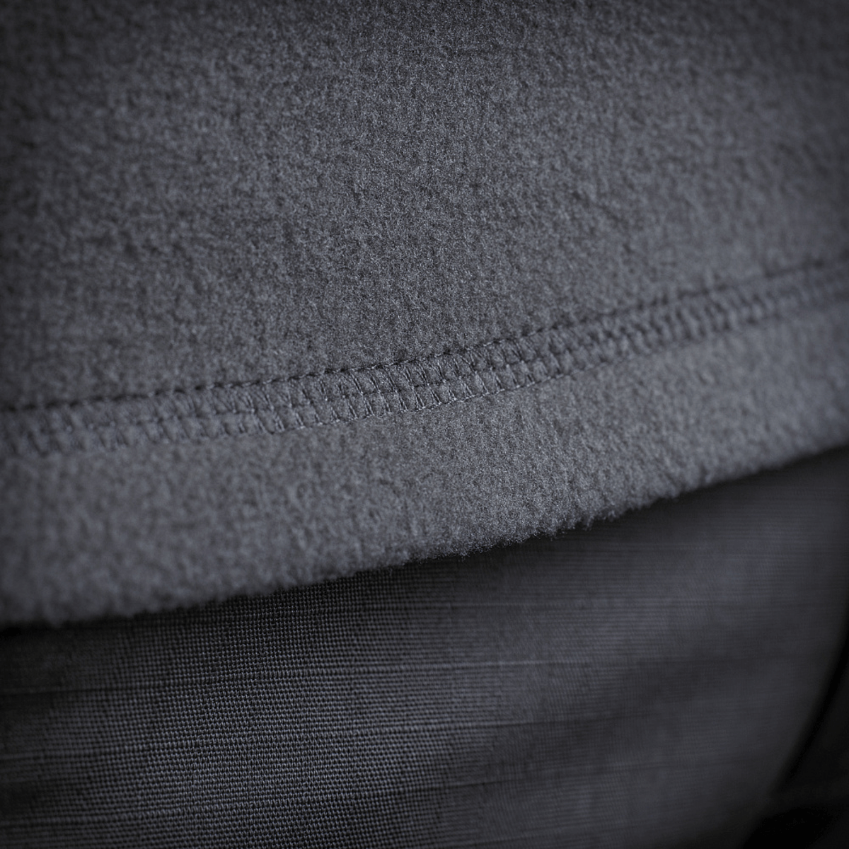 Yksityiskohta M-Tac Delta Polartec -fleece-takin kankaasta ja saumoista lähikuvassa.