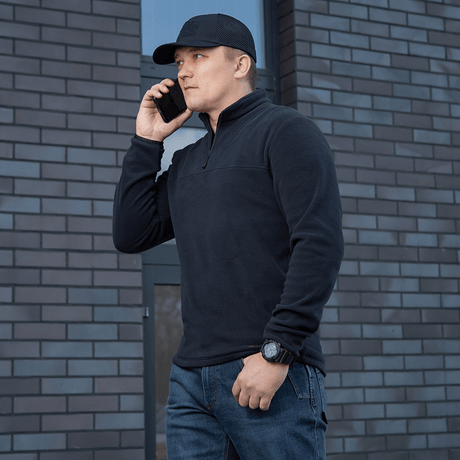 Mies käyttää mustaa M-Tac Delta Polartec -fleece-takkia, puolivetoketjulla.