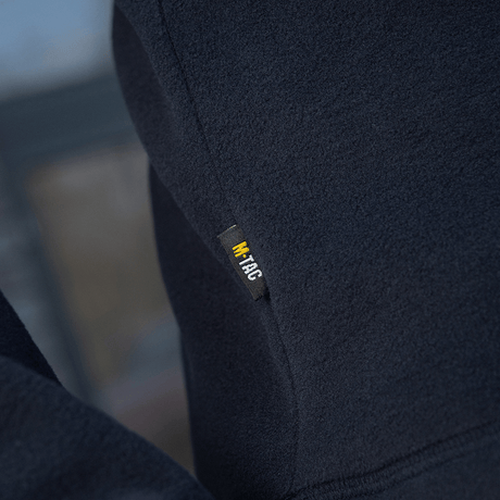 Lähikuva M-Tac Delta Polartec -fleece-takista tummansinisenä; keskittyy merkkietikettiin.