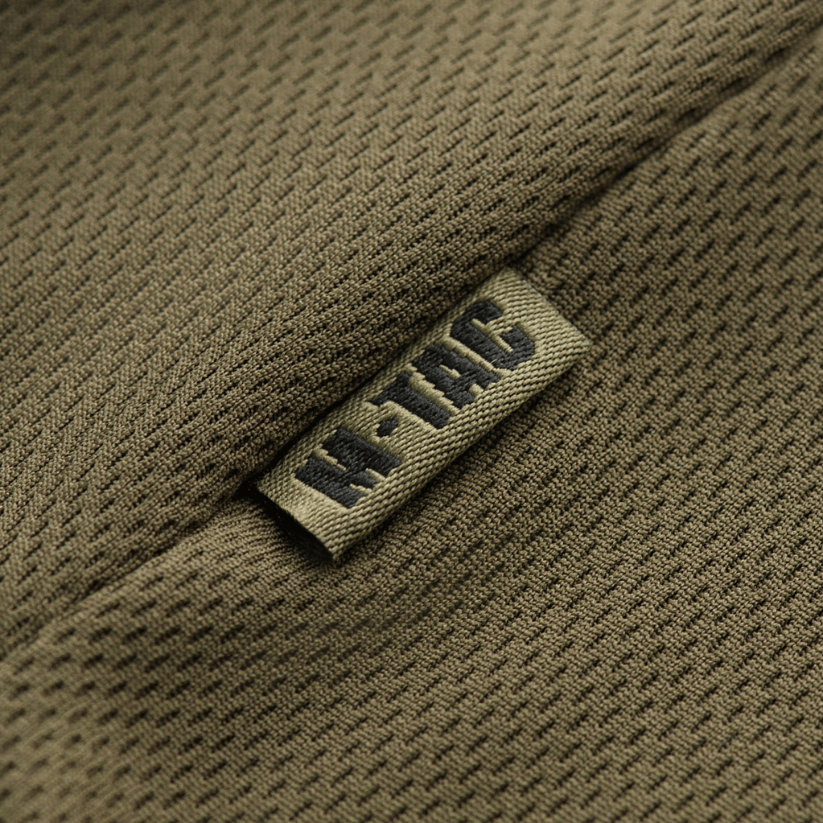 M-Tac Polo Elite Tactical Coolmax hengittävällä Coolmax®-kankaalla, suunniteltu poliisi- ja turvallisuustyöhön, lähikuva kankaan rakenteesta.