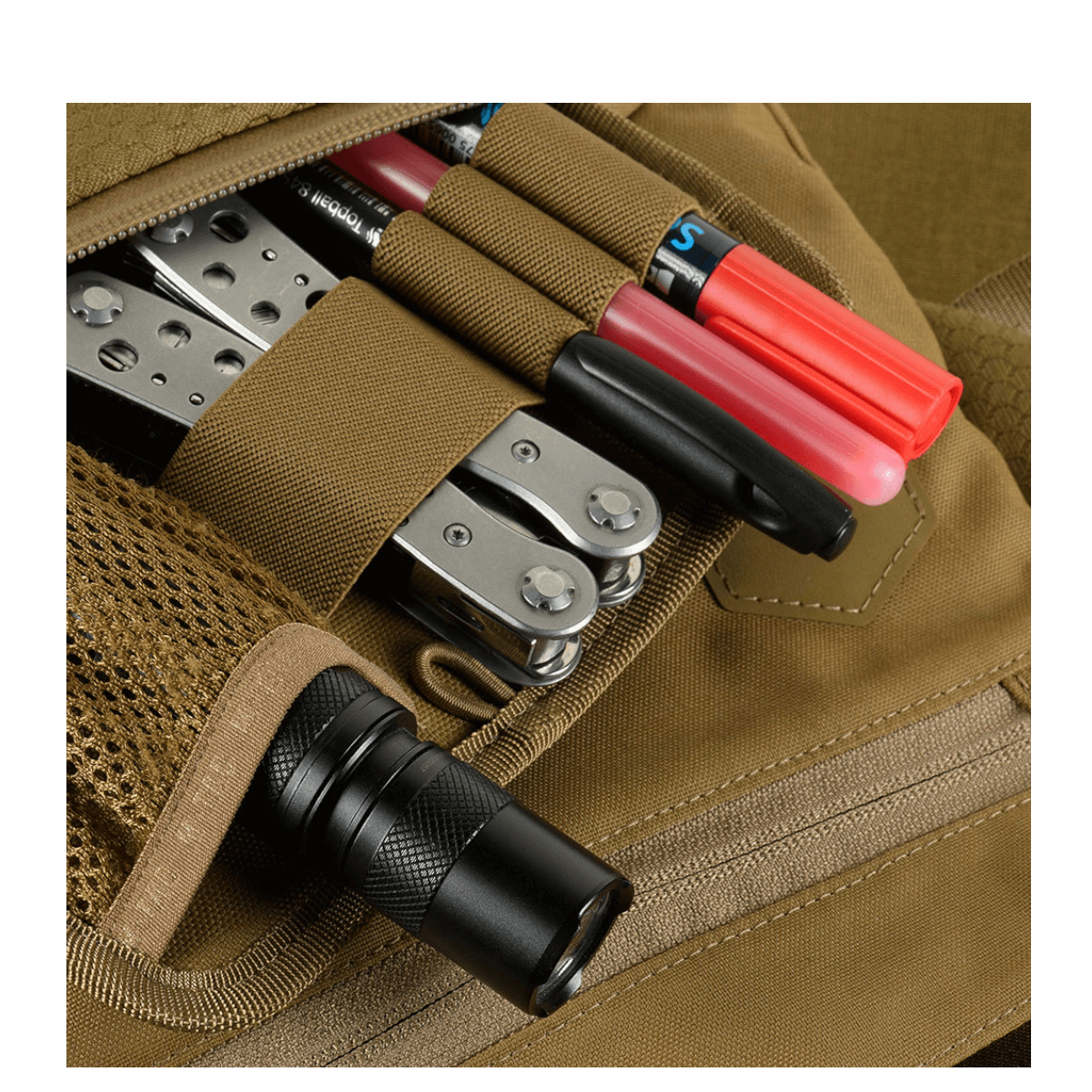 Tarkka kuva M-Tac Konvert Taske Elite -laukun käytännöllisestä varastoinnista, työkaluista ja taskulampusta, Cordura-materiaali.