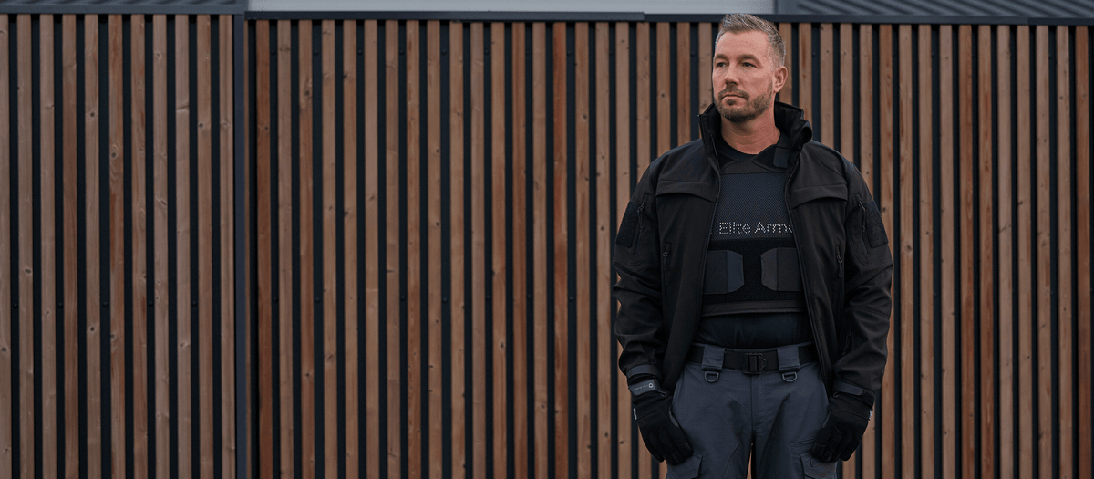 Mand iført Elite Armor RX2 skudsikker vest står ved port i professionelt sikkerhedsmiljø