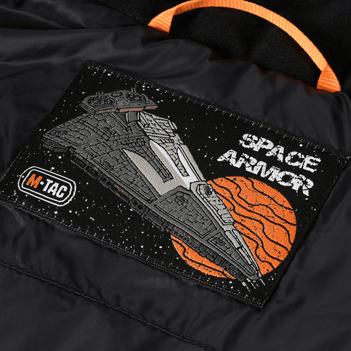 M-Tac Space Armor -takki Gen.II, jossa kangaskankaassa on avaruusaluksen embleemi.