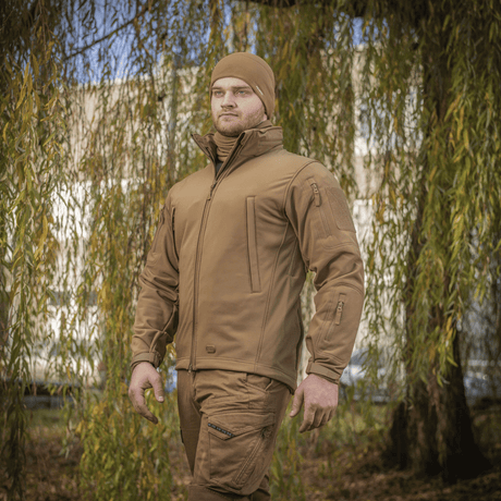 Mies pukeutuneena M-Tac Soft Shell -takkiin luonnonympäristössä.