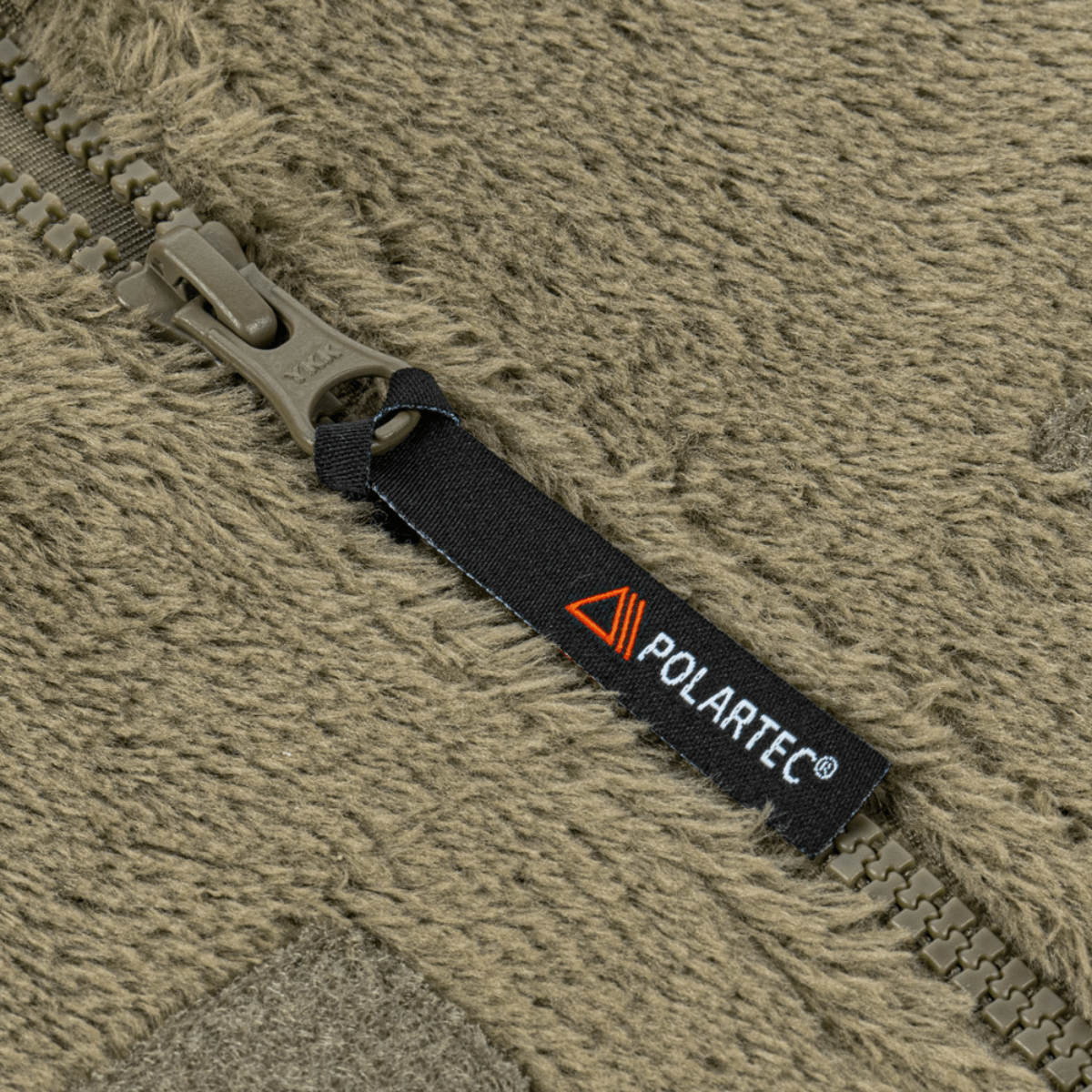 Lähikuva M-Tac Battle Fleece Polartec -takin vetoketjusta, Polartec-merkki näkyvissä.