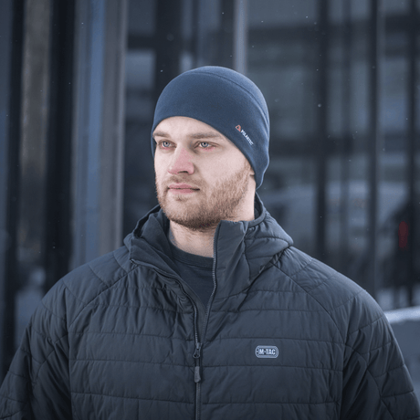 Mies pukeutuneena M-Tac Fleece Watch Cap Light Polartec talvihattu, valmistettu kestävästä Polartec-fleecestä korkealla lämmöneristyksellä kylmässä säässä.