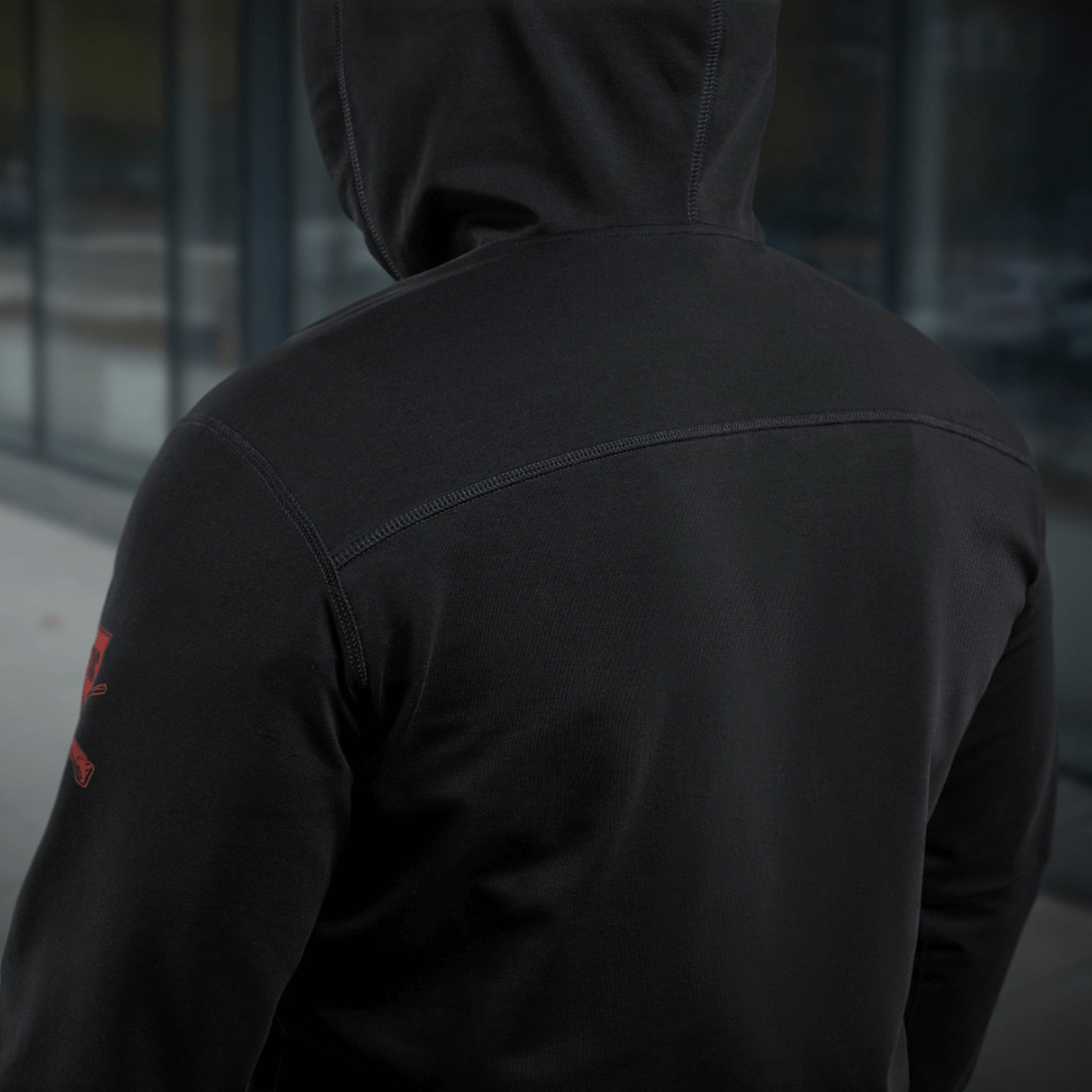 Henkilö M-Tac Hoodie Freedomissa sotilasaiheisella designilla, nähtynä takaa näyttämään selän yksityiskohdat, sopii ulkoiluun.