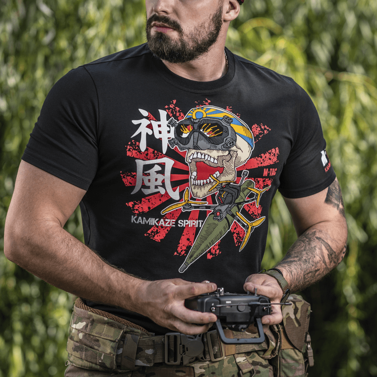 M-Tac T-Shirt Kamikaze Spirit -paita kalloprintillä ja FPV-goggles, puettuna henkilöön sotilasvarusteissa; kohdennettu FPV-operaattoreille.