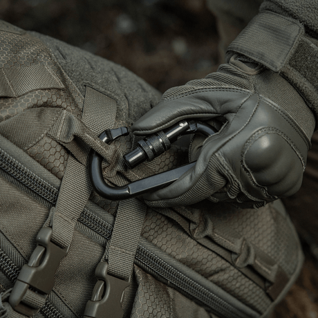 M-Tac karabiinihaka 10 cm kiinnitetty taktiseen laukkuun, valmistettu 40Cr-seosteräksestä, sopii köysiin ja lenkkeihin, trapetsimuotoinen.