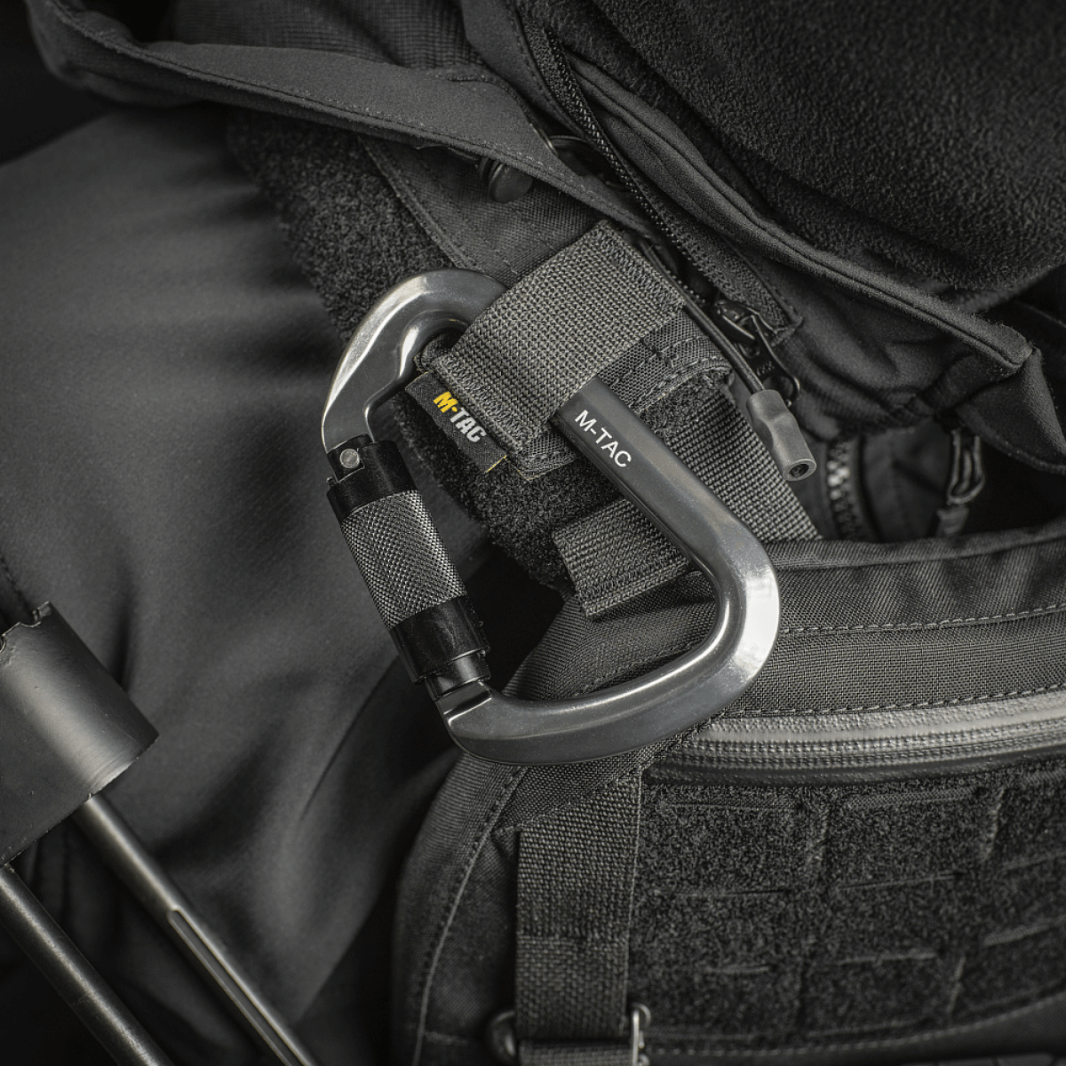 M-Tac Key-Lock karabiini alumiinia kiinnitettynä mustaan varusteeseen, sopii kiipeilyyn ja turvallisuuteen. Ergonominen muotoilu, CE EN362.