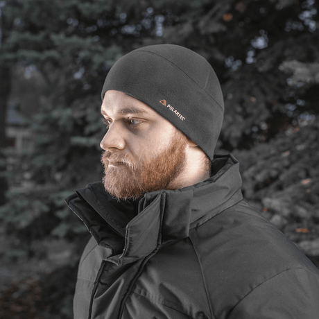 Mies pukeutunut M-Tac Fleece Watch Cap Light Polartec mustana en talviympäristössä