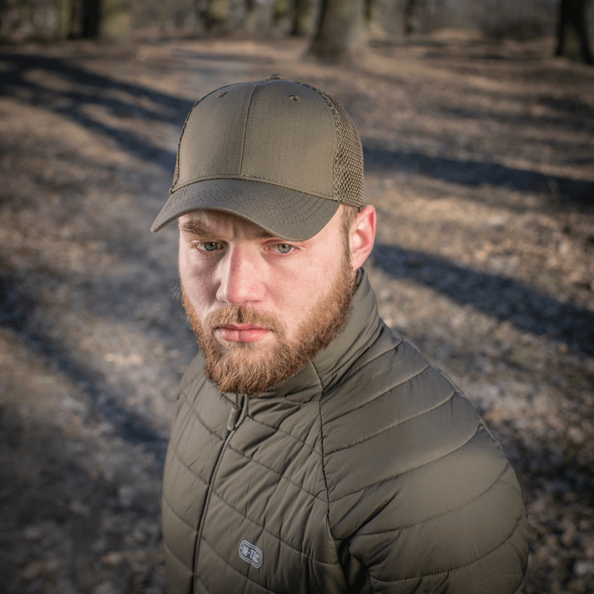 Mies käyttää M-Tac Mesh Flex Ripstop Baseball Cap en metsäympäristössä, käytännöllinen ulkokäyttöön.