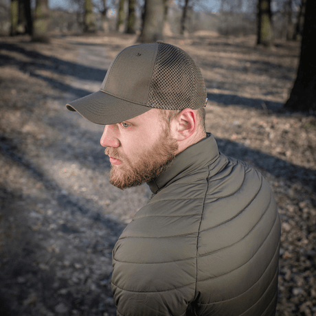 Mies metsässä käyttää M-Tac Mesh Flex Ripstop Baseball Capia; korostaa kestävyyttä ja ilmanvaihtoa ulko-olosuhteissa.