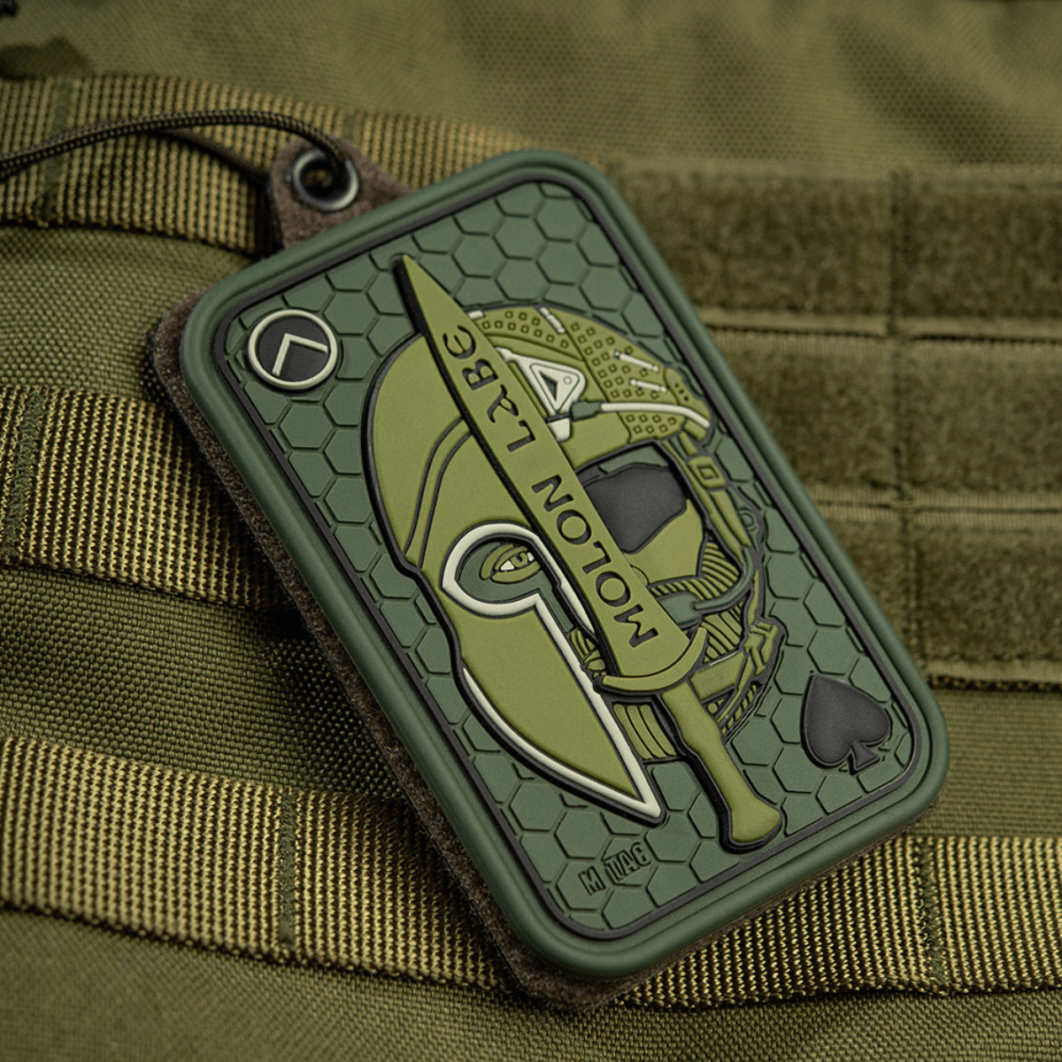 M-Tac Patch Molon Labe 3D PVC spartalainen kypärä ja miekka, kiinnitetty taktiseen laukkuun Velcro-kiinnityksellä.