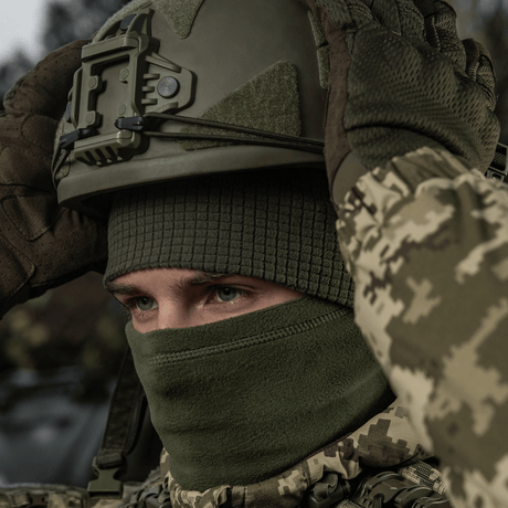Henkilö käyttää M-Tac Rip-Stop Fleece Hjelmlineriä ja sotilaskypärää kylmässä säässä