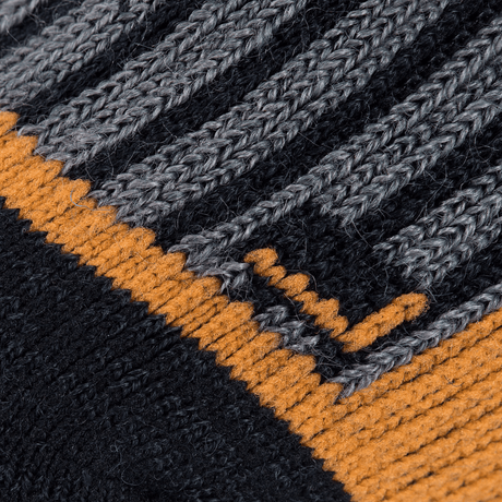Lähikuva M-Tac Sokker Polar Merino 40%:sta villaneulostruktuureilla harmaassa ja oranssissa. Suunniteltu lämpöön ja mukavuuteen ulkoaktiviteetteihin.