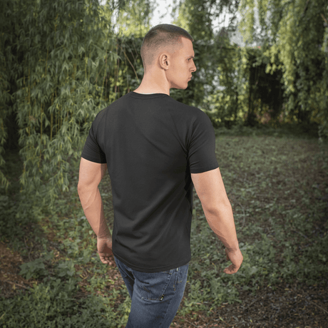 Mies pukeutuneena M-Tac Raglan T-Shirt 93/7, mukavat raglanhihat luonnonläheisessä ulkoilmassa.