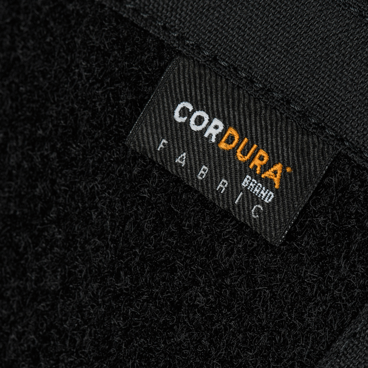 Lähikuva Cordura-merkkilapusta M-Tac Sphaera Hardsling Bag Large Elite med Velcro -laukussa, valmistettu kestävästä materiaalista.