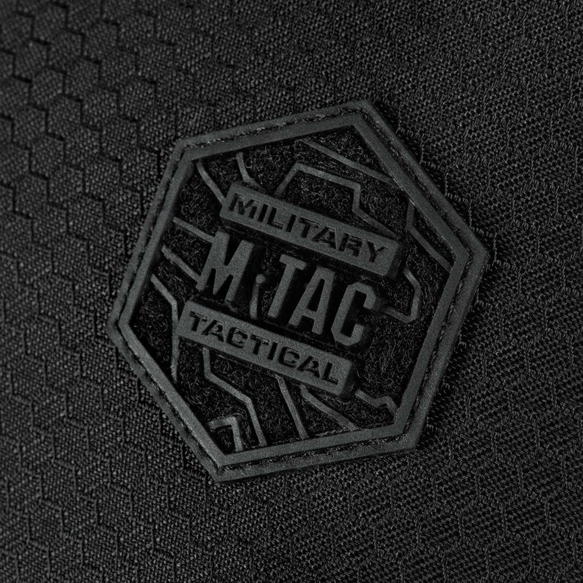 Lähikuva kuusikulmaisesta logosta M-Tac Sphaera Hex Hardsling Bag Large Elitessä mustalla taustalla.