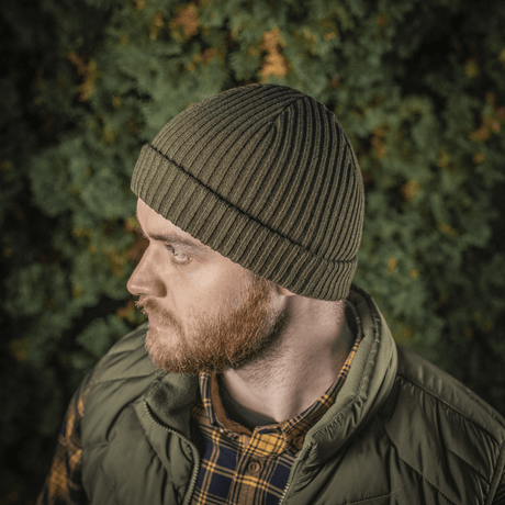 Mies käyttää M-Tac Watch Cap 100% Akryl -neulepipoa metsänvihreänä, tehty teollisesta kaksinkertaisesta akryylineuloksesta lämmöksi ja kestävyydelle.