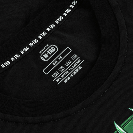 Lähikuva M-Tac T-Shirt Night Vision -etiketistä mustalla, puuvillasekoite mainittu, selkeät pesuohjeet ja koko XS.