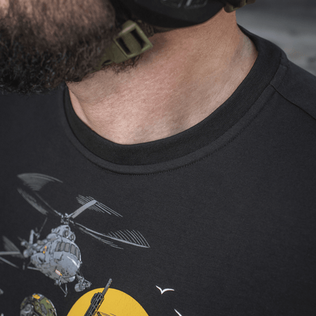 Mies pukeutuneena M-Tac T-Shirt Surf Clubiin, design innoittanut ukrainalaiset erikoisoperaatiot ja surffikohtaukset; lähikuva painatuksesta.