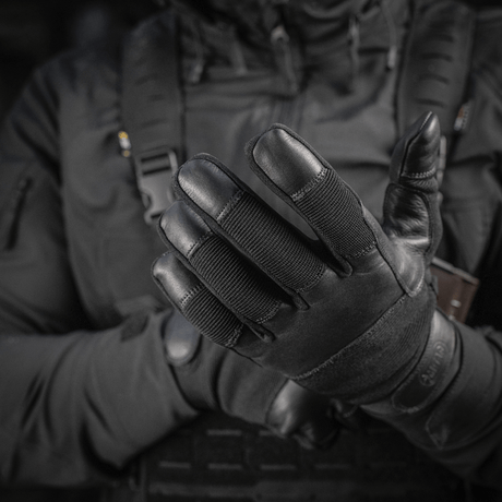 Henkilö pukeutuneena M-Tac Handsker Police Gen.2 en, suunniteltu turvallisuuteen ja mukavuuteen taktisiin tilanteisiin.