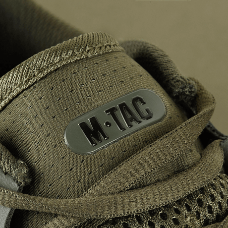 Yksityiskohta M-Tac Summer Light Sneakers synteettisistä materiaaleista, hengittävä muotoilu ja vahvistettu kärki ja kantapää.