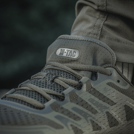 M-Tac Tactical Summer Sport -tennarit käytössä lämpimässä säässä, valmistettu hengittävistä ja kulutusta kestävästä synteettisestä materiaalista kumivahvistuksella