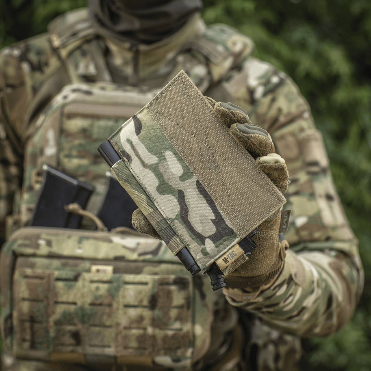 M‑Tac Tourniquet Pouch Elastic Gen.5 sotilaan pitämänä maastokuvioisessa univormussa, sopiva CAT-tourniquetille taktisessa varustuksessa.