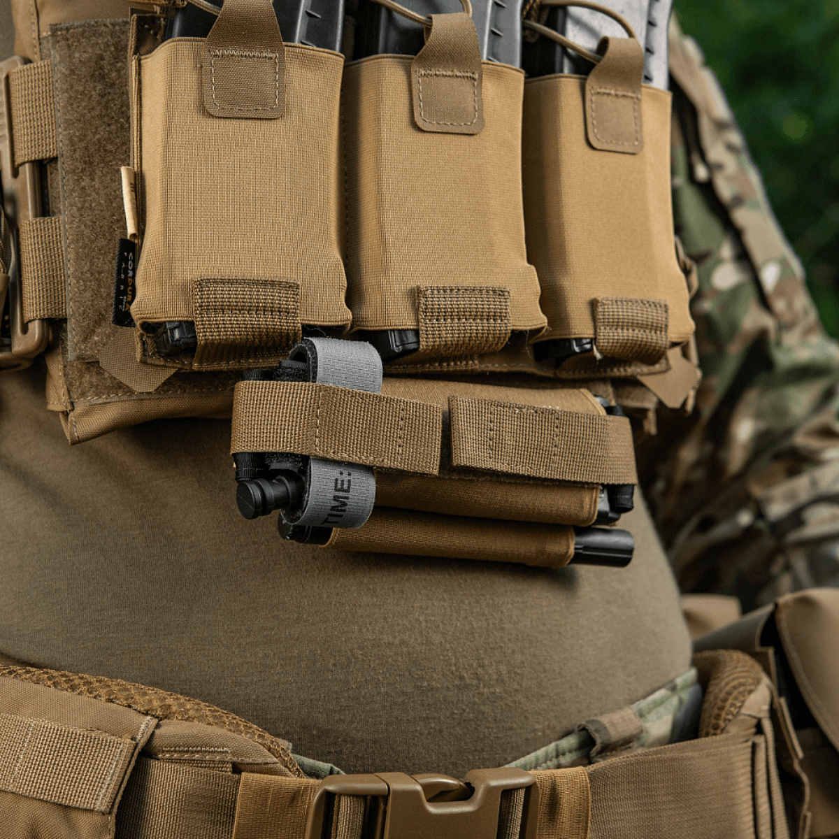 M‑Tac Tourniquet Pouch Elastic Gen.5 asennettuna taktiseen varustukseen, esittelee Cordura 500D -materiaalin ja nopean pääsyn suunnittelun.