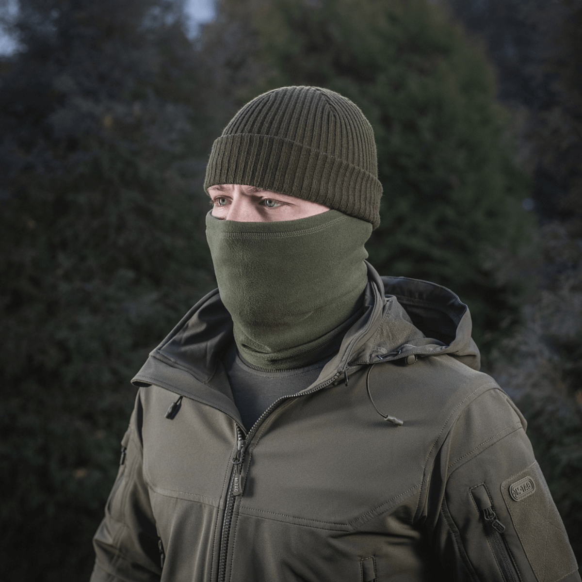 Henkilö käyttää oliivinvihreää M-Tac Tube Scarf Polartec -huivia talviulkoiluun.