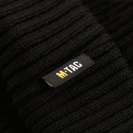 Lähikuva M-Tac Watch Cap 100% Akryl mustasta kankaasta ja M-Tac-logosta, ihanteellinen kylmään säähän. Matala malli ja teollinen kaksinkertainen neulos.