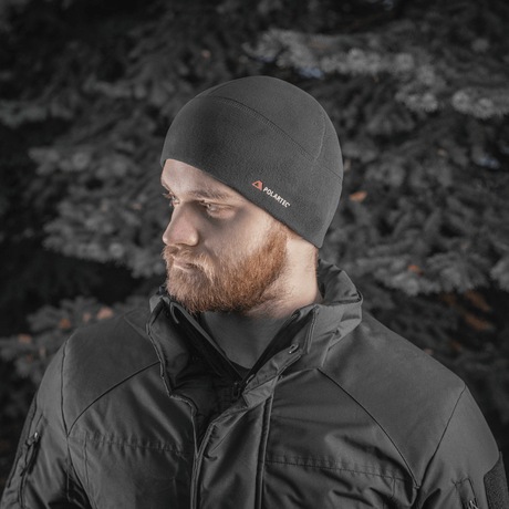 Mies pukeutuneena M-Tac Fleece Watch Cap Light Polartec talvimaisemassa.